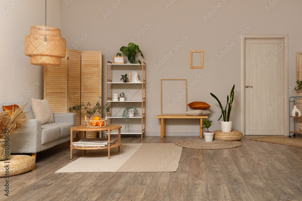 Interior of modern living room with grey sofa, coffee table and folding screen