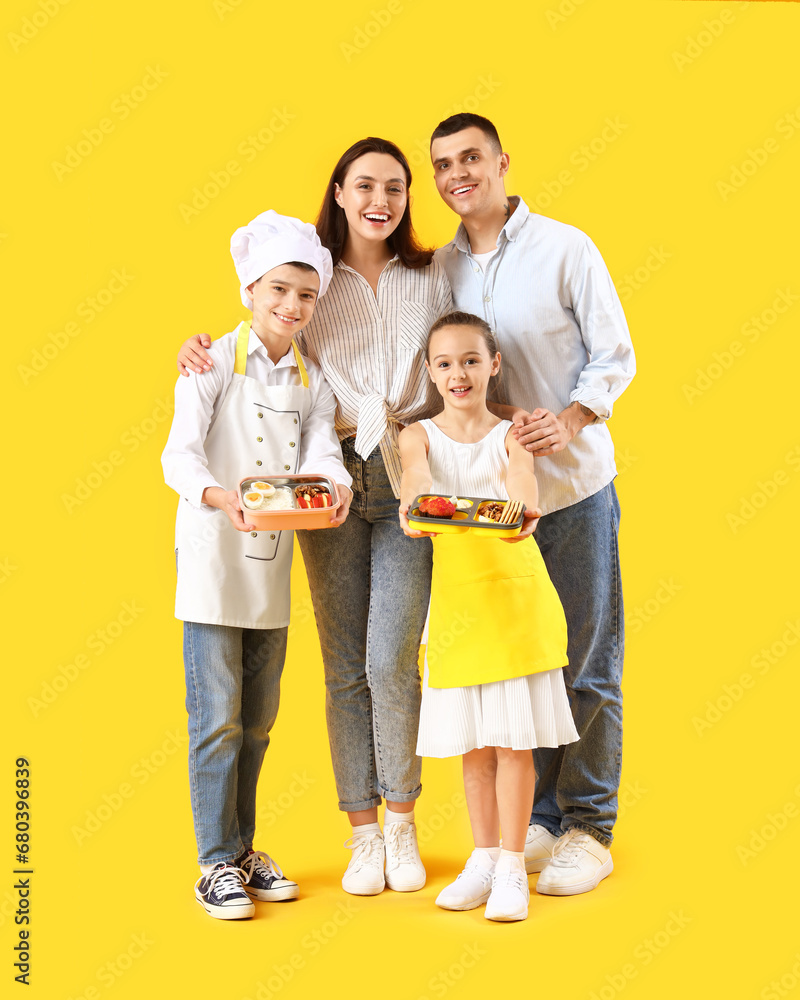 Happy family with lunchboxes on yellow background