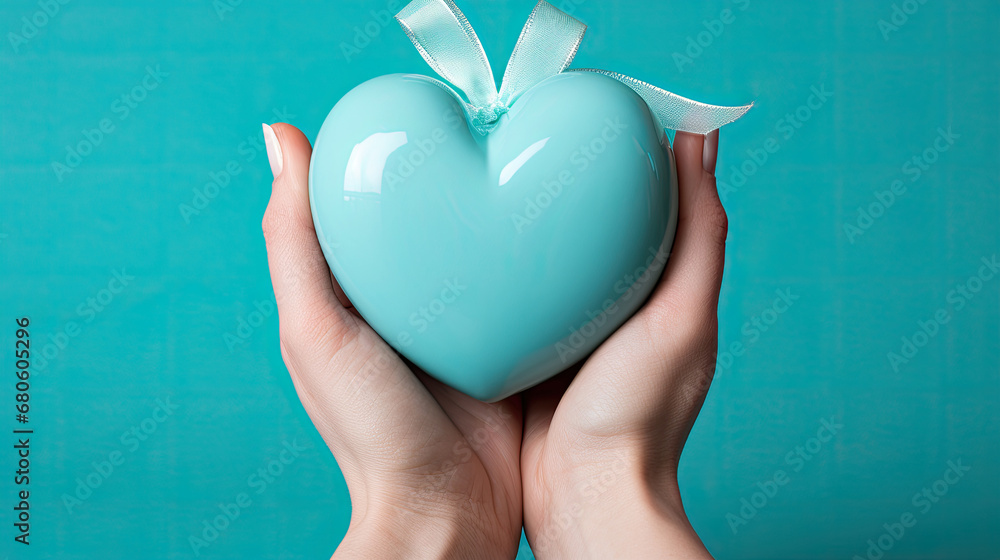 hand holding blue heart on blue background,copy space, top view