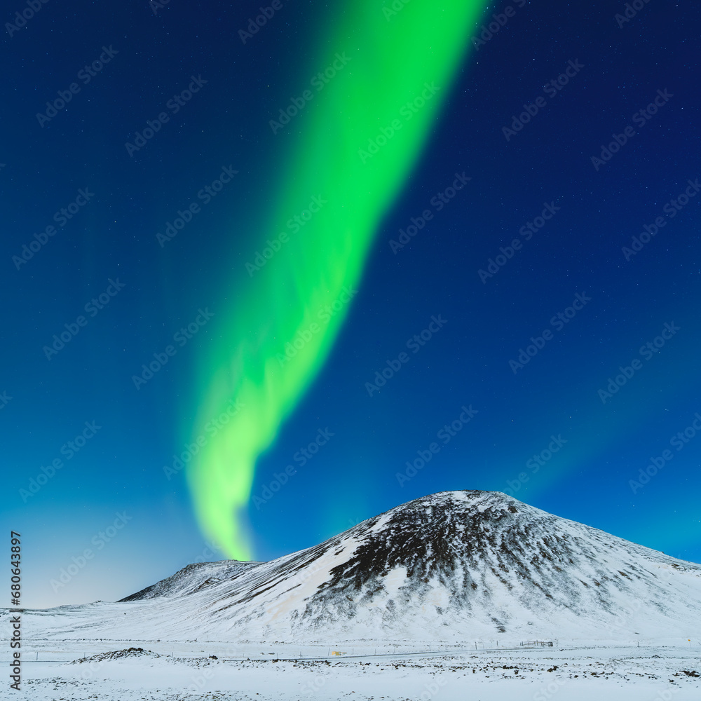 Aurora Borealis. Northern lights and starry skies. Nature. Scandinavian countries. Snow and ice on the mountains. Landscape in winter time. Photo for background and wallpaper.