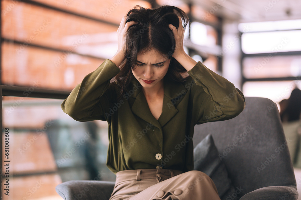 Young businesswoman stressed out at work until headache