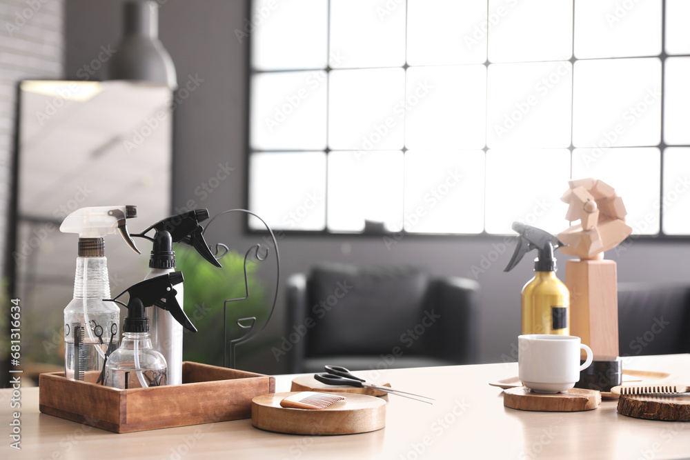 Different hairdressing tools and tea cup on table in beauty salon