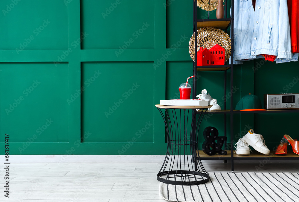 Interior of hall with shelving unit, clothes and table