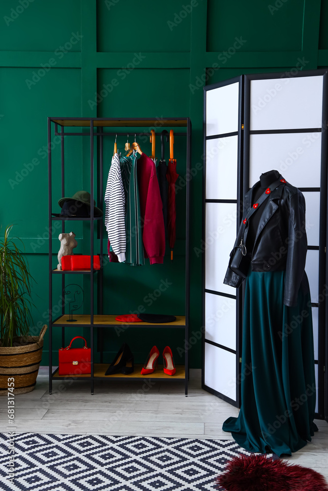 Shelving unit with clothes and accessories in interior of dressing room