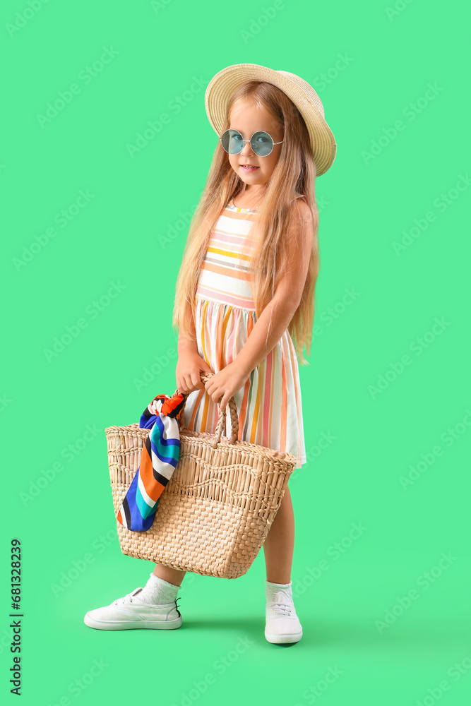 Cute little girl with bag on green background