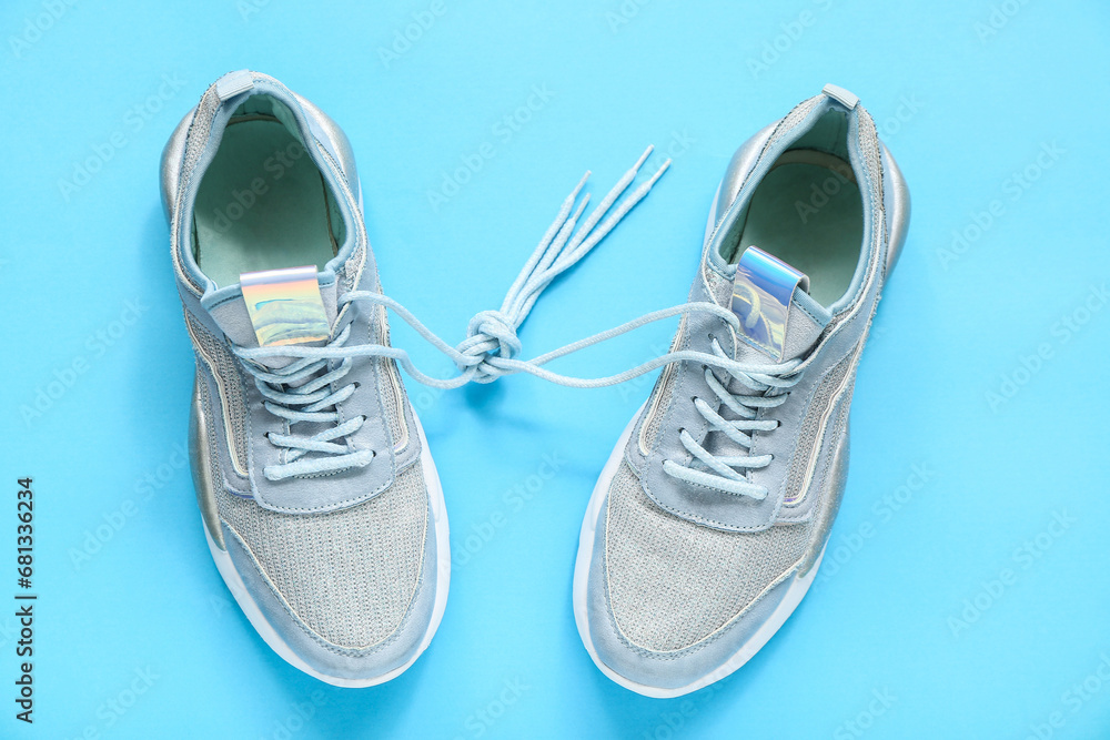 Stylish blue sneakers on color background