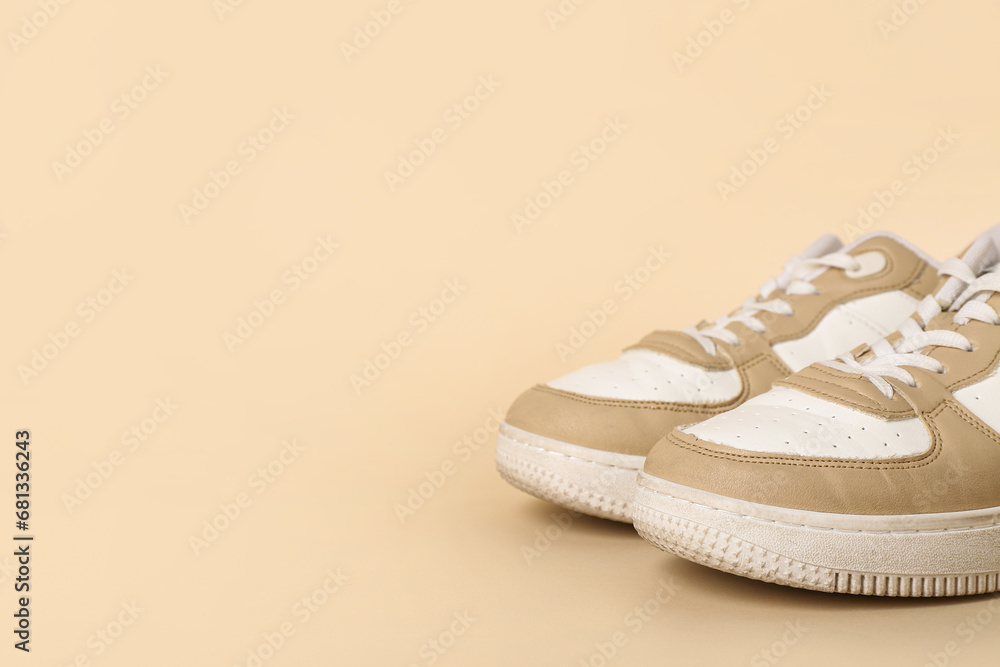 Stylish sneakers on beige background