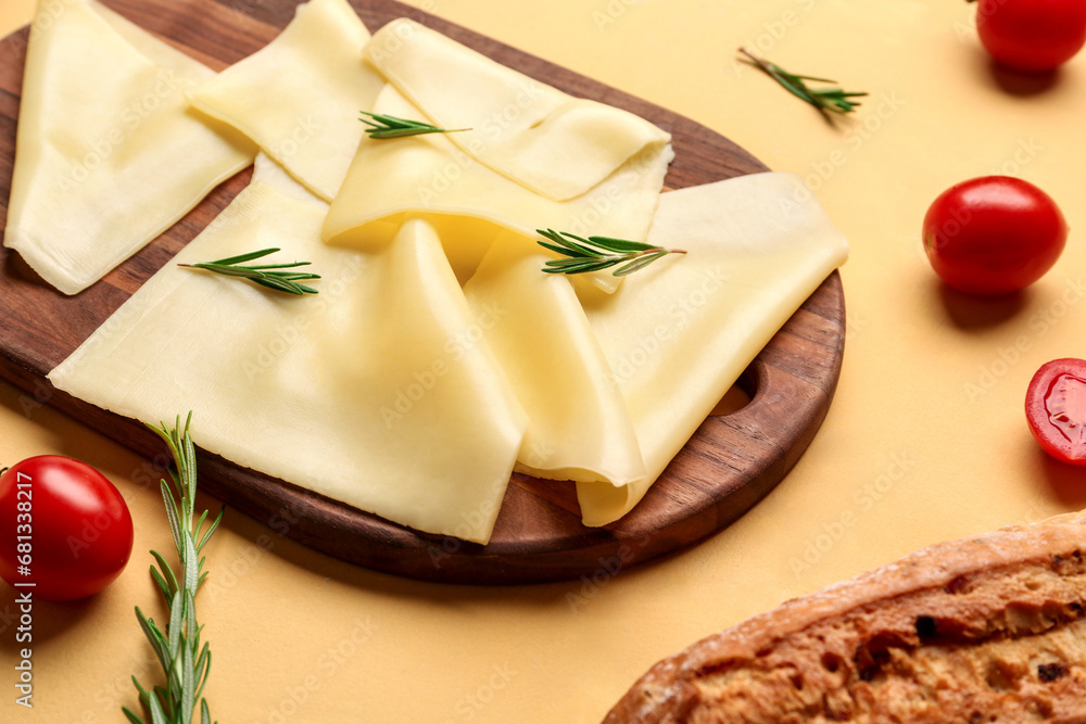 Board with tasty cheese slices, rosemary and tomatoes on beige background, closeup