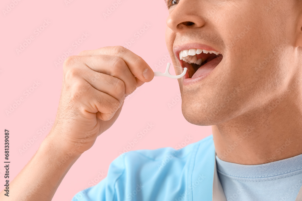 Male dentist with toothpick on pink background, closeup