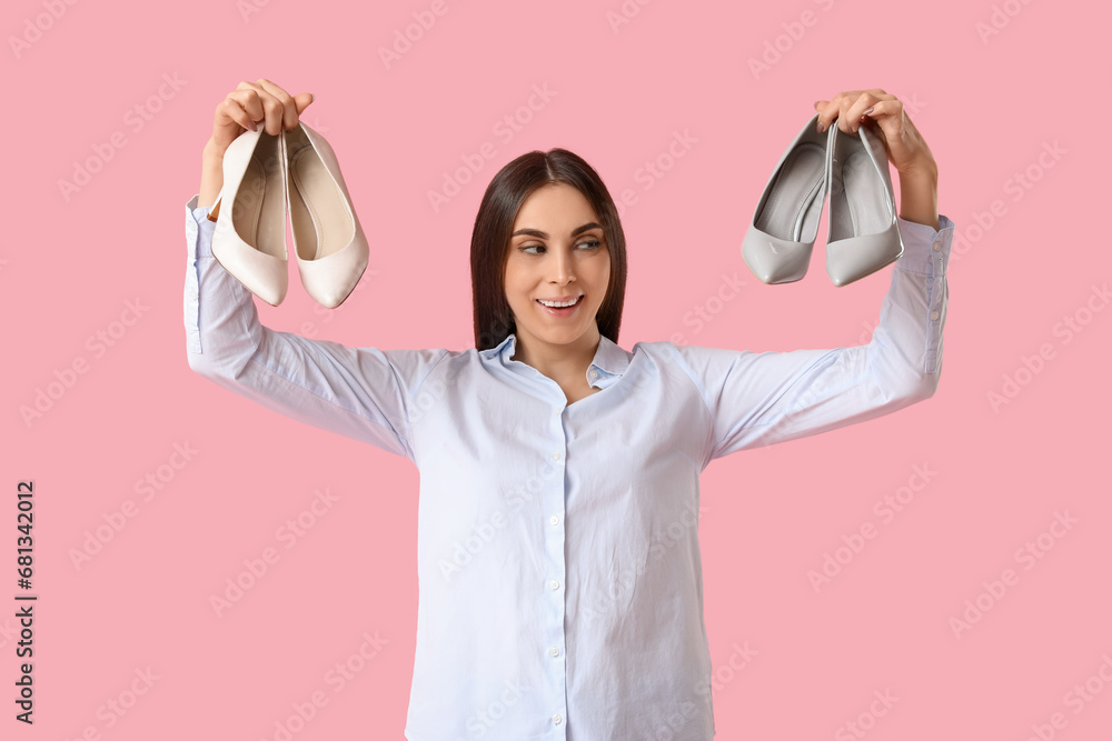 Beautiful young woman with different stylish high heels on pink background