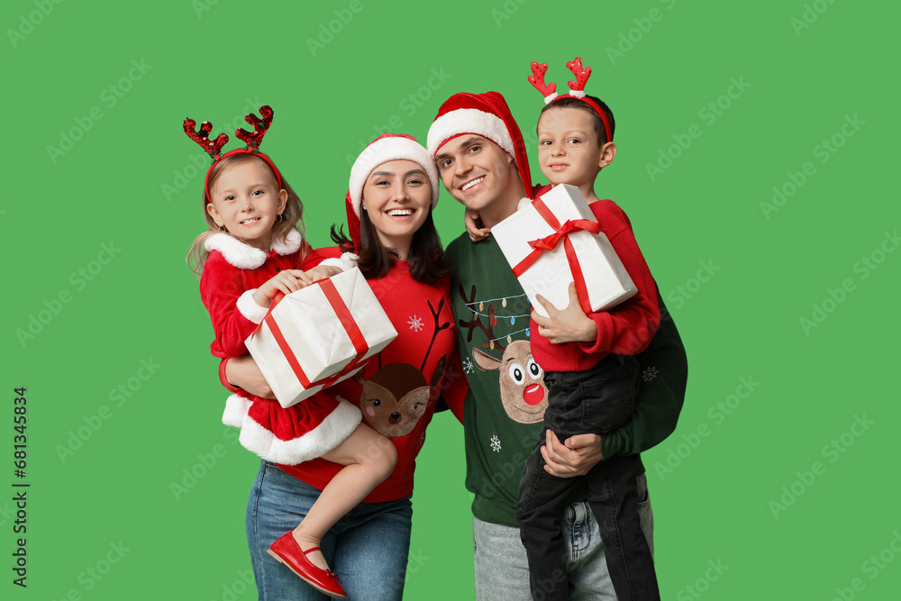 Happy family in Christmas clothes and gifts on green background