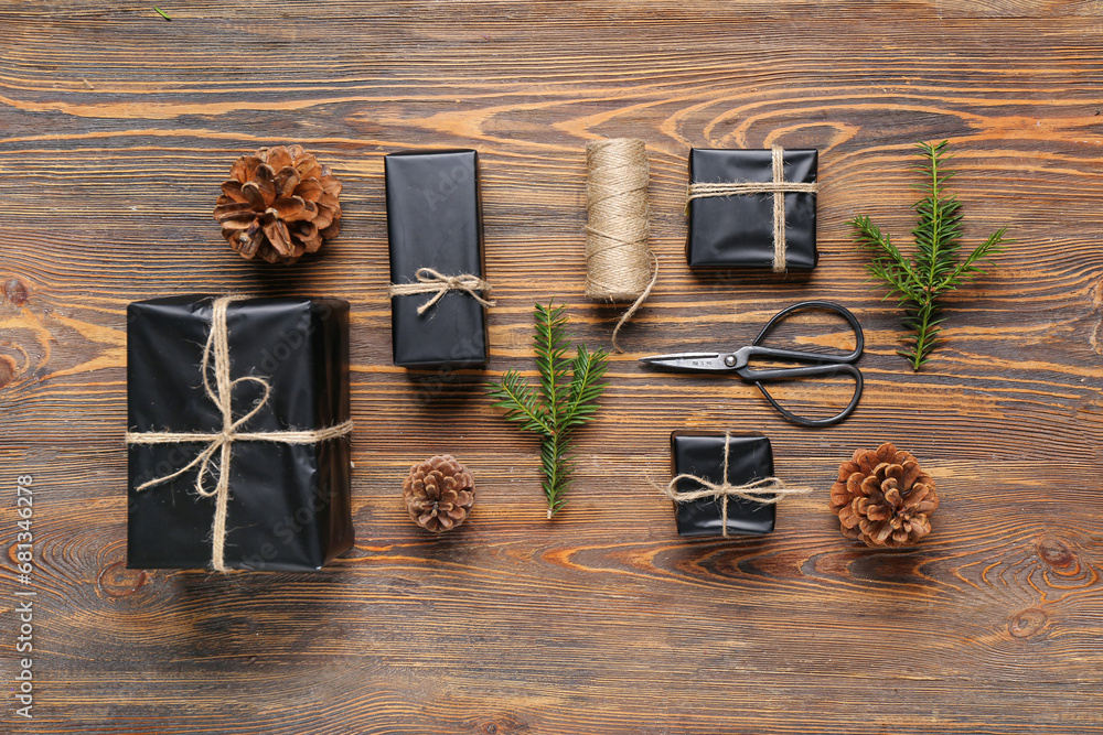 Pine cones with Christmas gift boxes and fir branches on wooden background