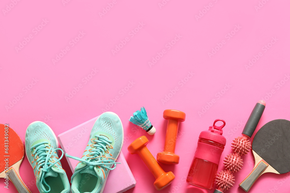 Different sports equipment and sneakers on pink background