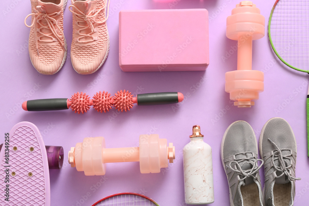 Different sports equipment and sneakers on lilac background