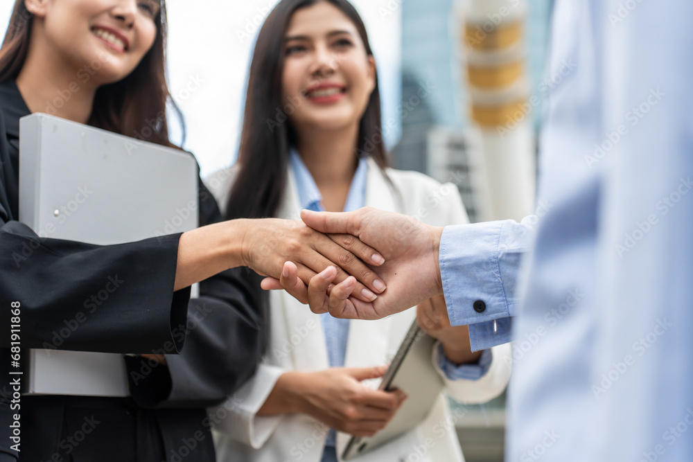 Close up of Asian businesswoman making handshake outdoor in the city. 