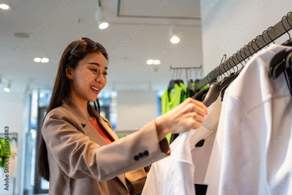 Asian beautiful young women look to product of clothes in shopping mall. 