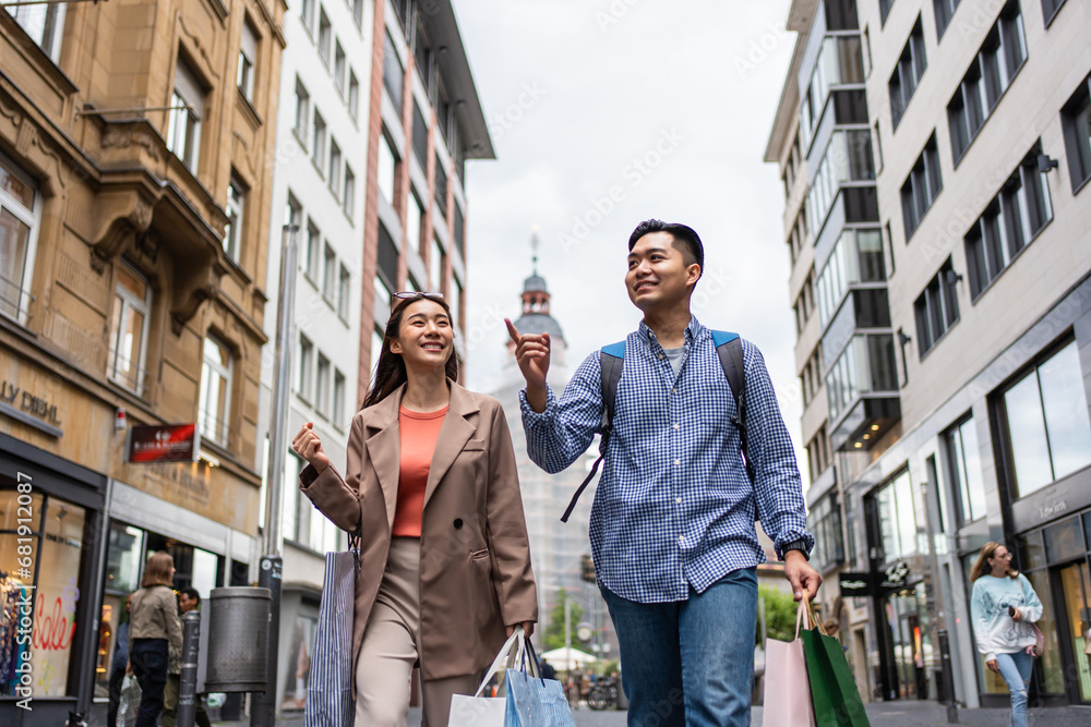 Asian young man and woman shopping goods outdoors in department store. 