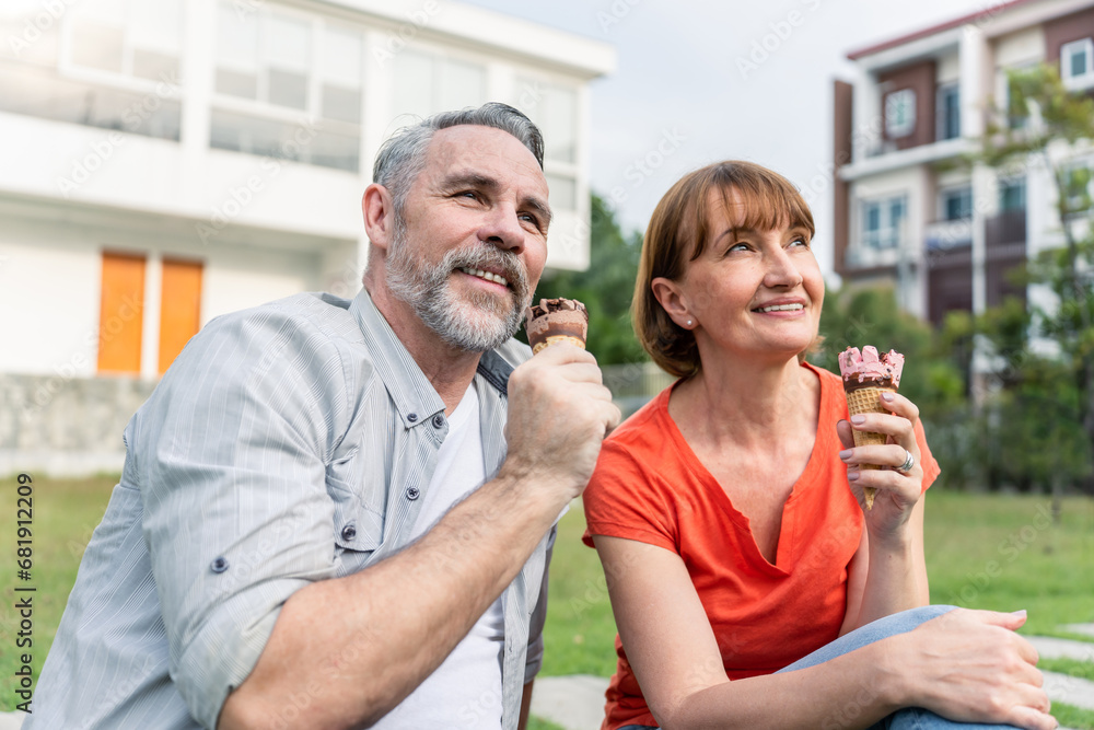 Caucasian senior man and woman having a picnic outdoors in the garden. 