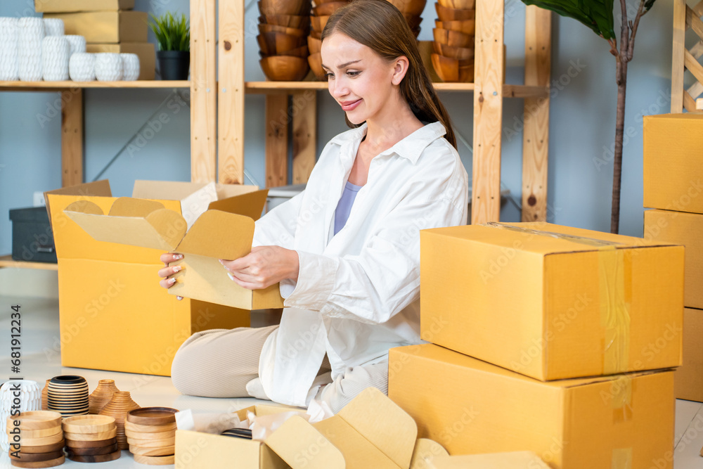 Caucasian young woman packing vase goods order into box for customer. 