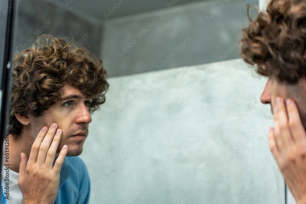 Caucasian young man washing and clean face with facial foam and water. 