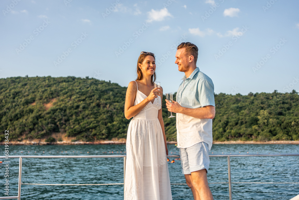 Caucasian young couple drinking champagne while having party in yacht.