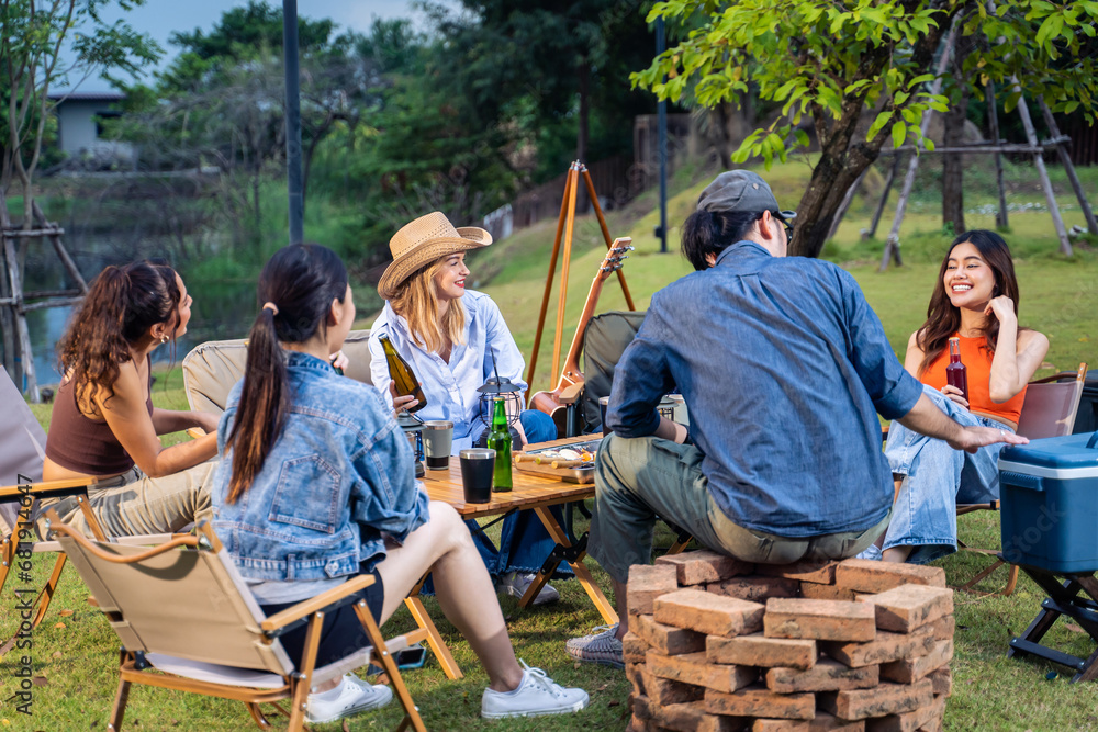 Group of diverse friend having outdoors camping party together in tent. 