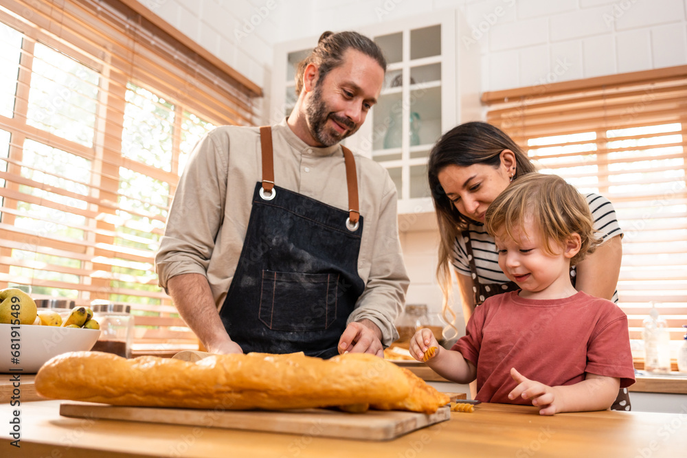 Caucasian attractive couple baking bakery with son in kitchen at home. 